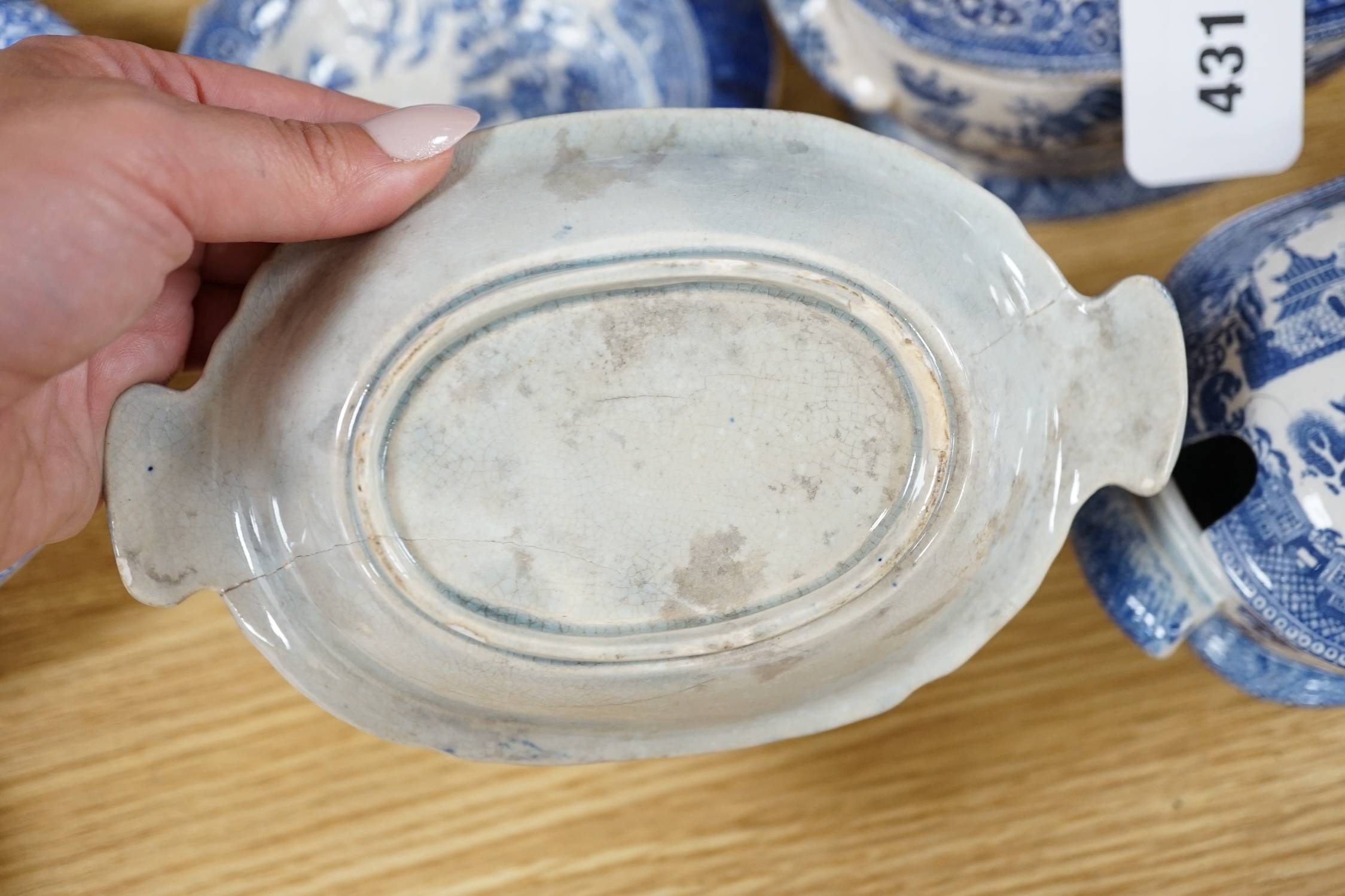 A mixed collection of Willow pattern blue and white dinnerware, including four tureens and covers, plates meat dishes etc. (large quantity). Condition - varied poor to fair to good